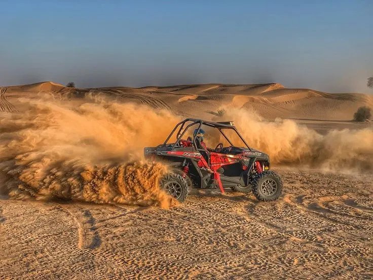 Dune buggy speeding through Agafay desert trails with sand flying.