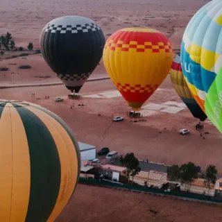 Colorful hot air balloons preparing for flight over Moroccan desert with LuxuryAirs