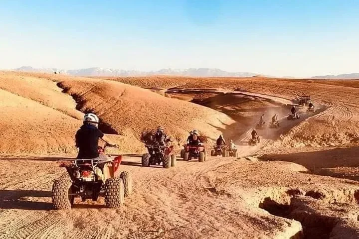 Tourists riding quad bikes through the rocky Agafay desert near Marrakech.