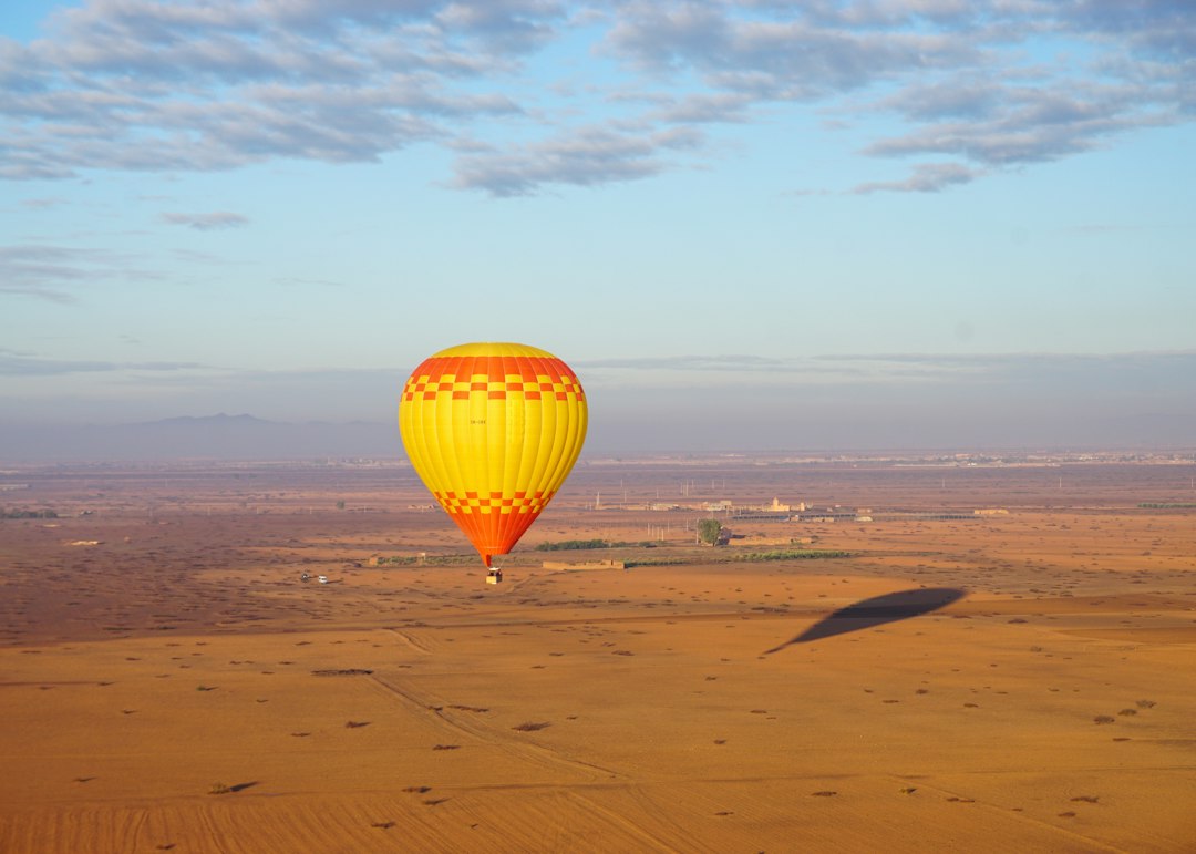 Illustrative hot air balloons floating above the Marrakech countryside at sunrise